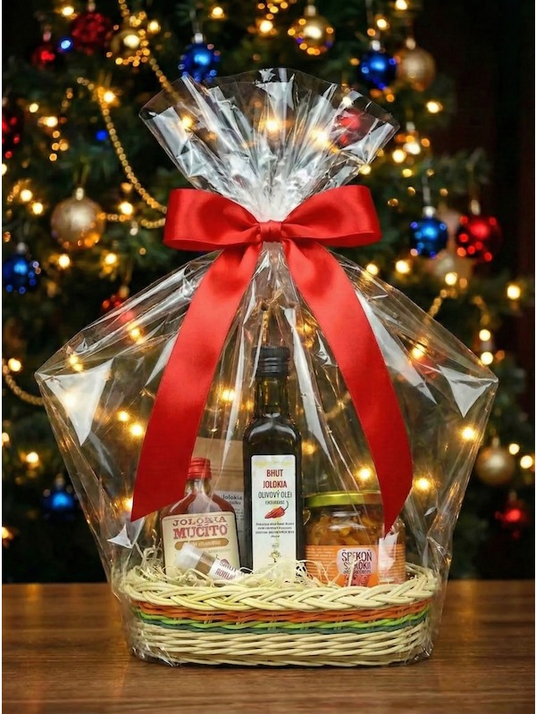 Dárkový koš chilli Bhut Jolokia, zabalený v celofánu, s dlouhou červenou mašličkou a na pozadí stojí svítící Vánoční stromek